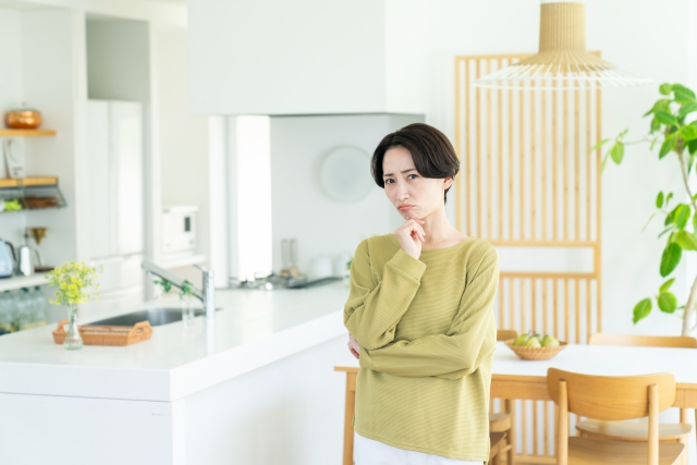 室内で悩んでいる女性