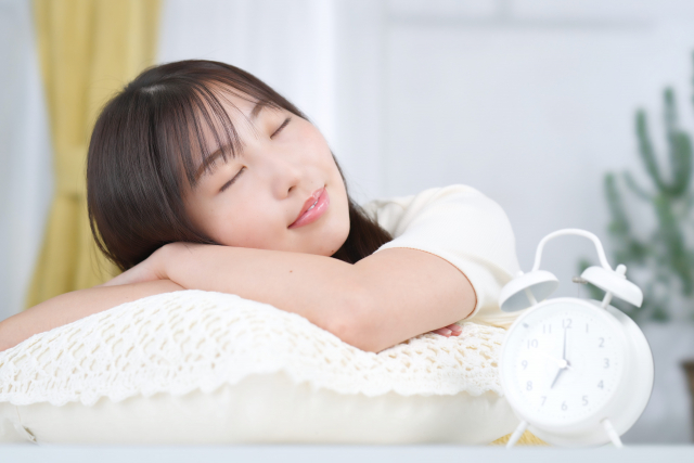 ベッドで寝て休んでいる女性