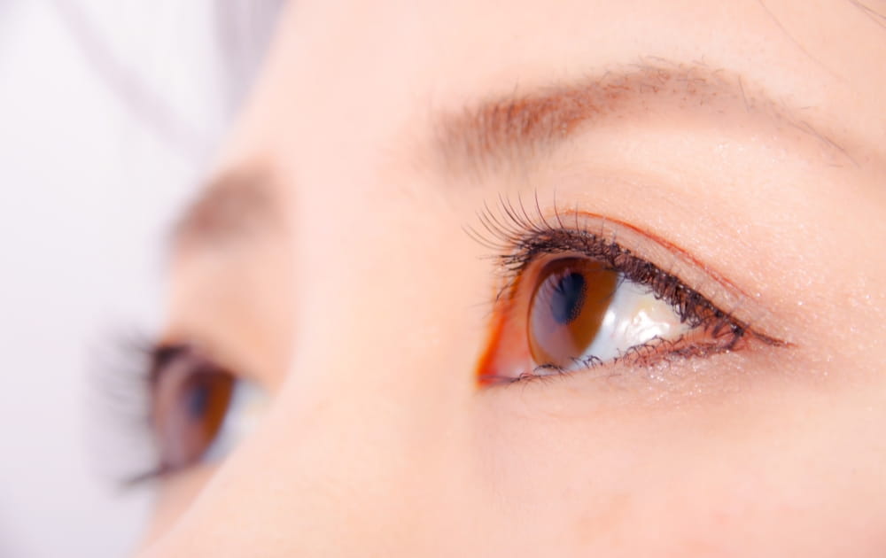 上を見上げる女性の目元