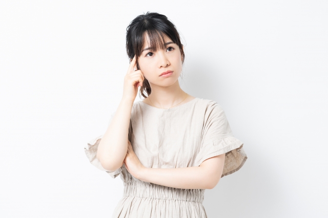 顎に手を当てて考える女性